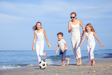 Image showing Mother and children playing on the beach at the day time.