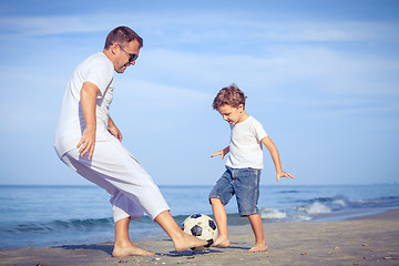 Image showing Father and son playing on the beach at the day time.