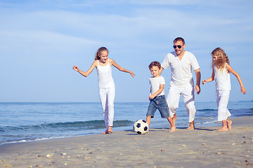 Image showing Father and children playing on the beach at the day time.