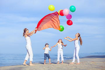 Image showing Mother and children playing on the beach at the day time.