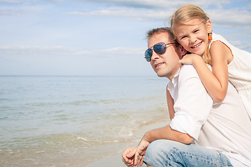 Image showing Father and daughter playing on the beach at the day time.