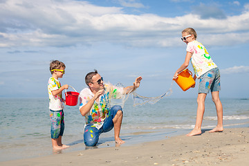 Image showing Father and children playing on the beach at the day time.