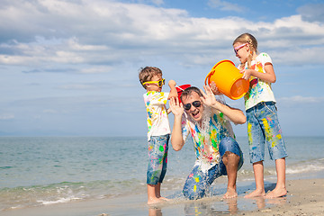 Image showing Father and children playing on the beach at the day time.