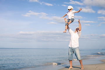 Image showing Father and son playing on the beach at the day time.