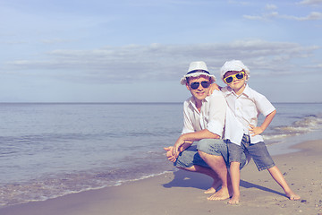 Image showing Father and son playing on the beach at the day time.