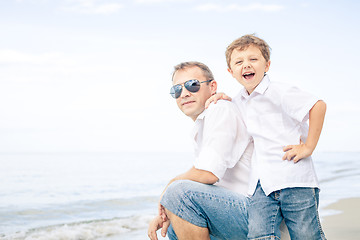 Image showing Father and son playing on the beach at the day time.