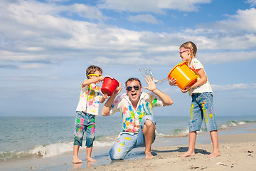 Image showing Father and children playing on the beach at the day time.