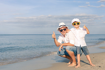 Image showing Father and son playing on the beach at the day time.