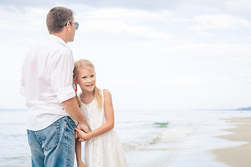 Image showing Father and daughter playing on the beach at the day time.