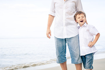 Image showing Father and son playing on the beach at the day time.