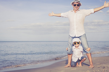 Image showing Father and son playing on the beach at the day time.