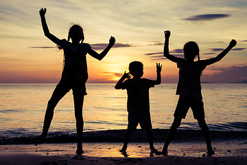 Image showing Happy children playing on the beach at the sunset time.