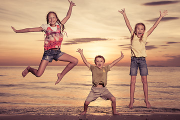 Image showing Happy children playing on the beach at the sunset time.