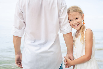 Image showing Father and daughter playing on the beach at the day time.