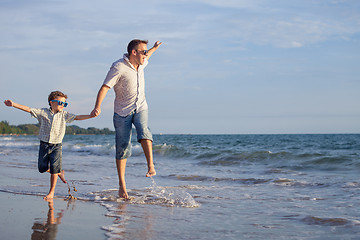 Image showing Father and son playing on the beach at the day time.