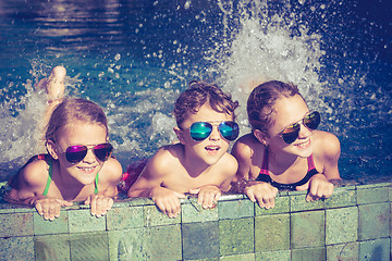 Image showing happy children  playing on the swimming pool at the day time