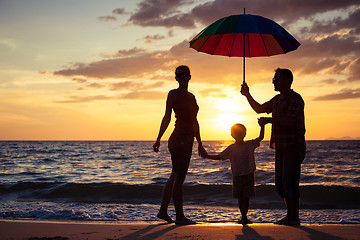 Image showing Silhouette of happy family who playing on the beach at the sunse