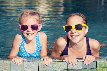 Image showing Two happy children  playing on the swimming pool at the day time