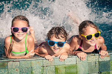 Image showing happy children  playing on the swimming pool at the day time