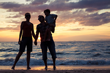 Image showing Silhouette of happy family who playing on the beach at the sunse