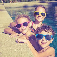 Image showing happy children  playing on the swimming pool at the day time