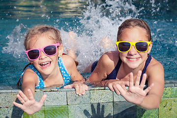 Image showing Two happy children  playing on the swimming pool at the day time