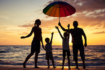 Image showing Silhouette of happy family who playing on the beach at the sunse