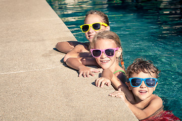 Image showing happy children  playing on the swimming pool at the day time