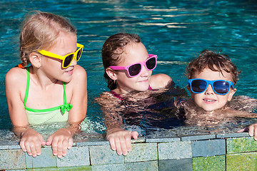 Image showing happy children  playing on the swimming pool at the day time