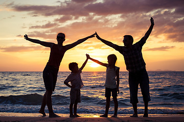 Image showing Silhouette of happy family who playing on the beach at the sunse