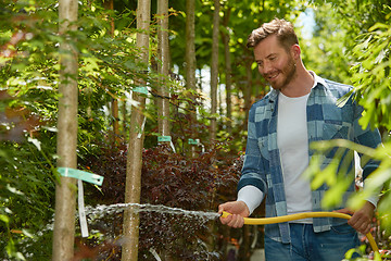 Image showing Man watering plants in garden