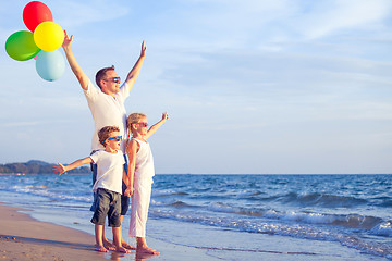 Image showing Father and children playing on the beach at the day time.