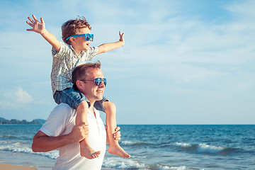 Image showing Father and son playing on the beach at the day time.