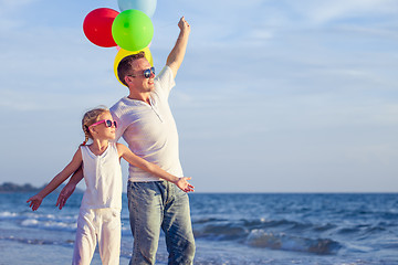 Image showing Father and daughter playing on the beach at the day time.