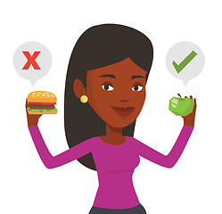 Image showing Woman choosing between hamburger and cupcake.