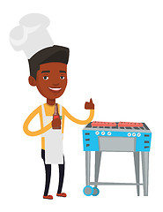 Image showing Man cooking meat on gas barbecue grill.