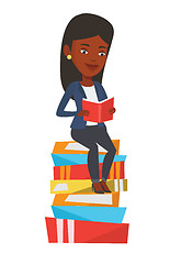 Image showing Student sitting on huge pile of books.