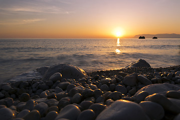 Image showing Sunrise, sea and pebble beach