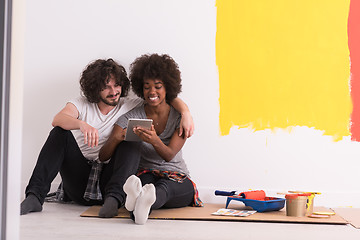 Image showing young multiethnic couple relaxing after painting