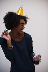 Image showing black woman in party hat blowing in whistle