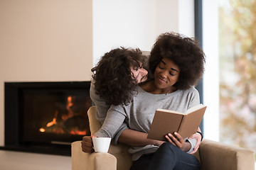 Image showing multiethnic couple hugging in front of fireplace