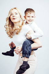 Image showing young modern blond curly mother with cute son together happy smiling family posing cheerful on white background, lifestyle people concept, sister and brother friends