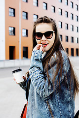 Image showing young pretty hipster girl student with coffee cup posing adorable smiling, lifestyle people concept outdoor