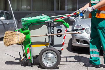 Image showing Worker of cleaning company in green uniform with garbage bin.