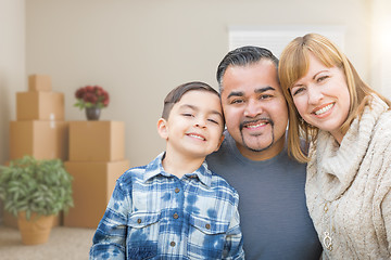 Image showing Mixed Race Family In Empty Room With Moving Boxes and Plants.