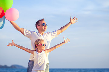 Image showing Father and daughter playing on the beach at the day time.