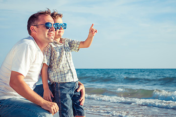 Image showing Father and son playing on the beach at the day time.