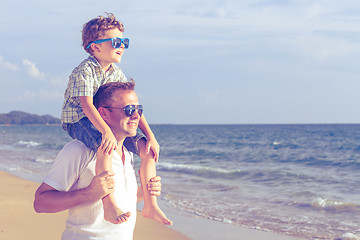 Image showing Father and son playing on the beach at the day time.