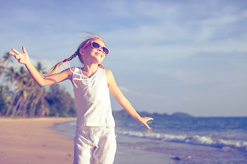 Image showing Little girl  dancing on the beach at the day time.
