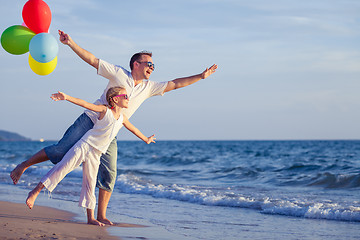 Image showing Father and daughter playing on the beach at the day time.